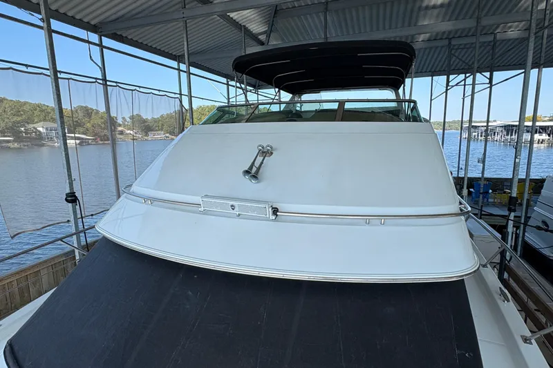 Slide: The Image of 2002 Carver 506 Motor Yacht docked under a covered marina with scenic lake view. - 22