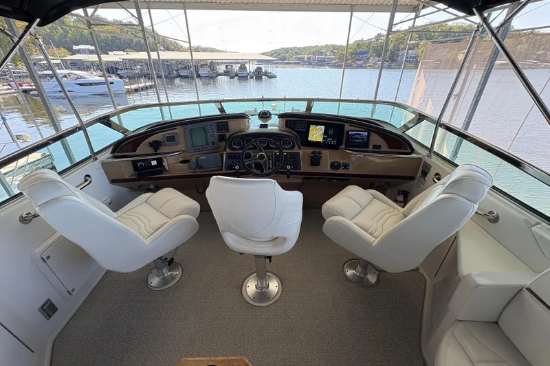 Slide: The Image of Helm of 2002 Carver 506 Motor Yacht with three white captain chairs and navigation equipment. - 23