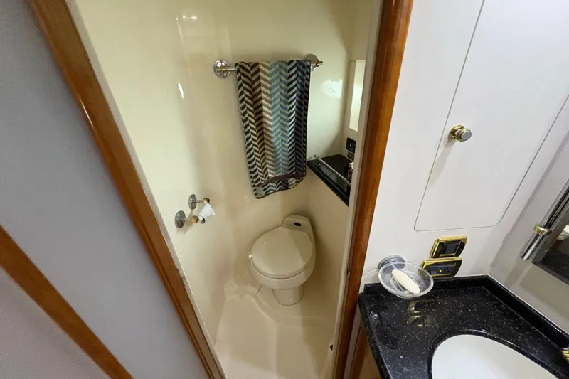 Slide: The Image of 2002 Carver 506 Motor Yacht bathroom with toilet, sink, and towel rack. - 50