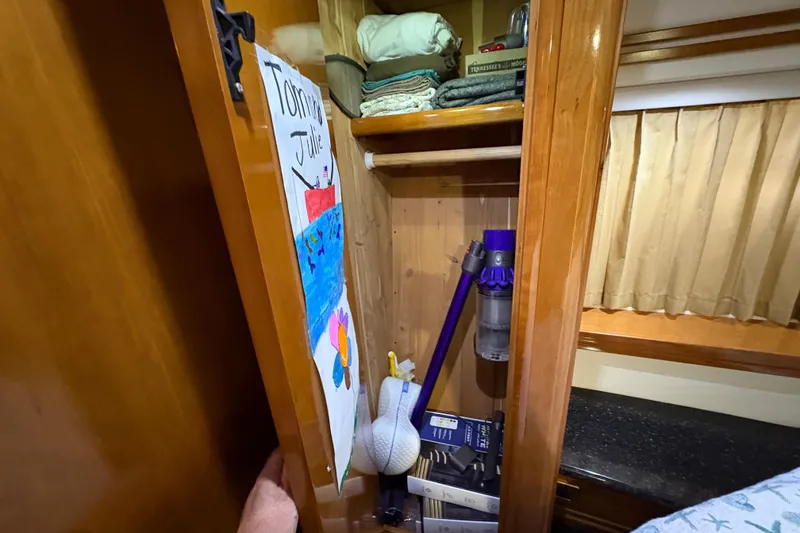 Slide: The Image of Interior of 2002 Carver 506 Motor Yacht showing closet with cleaning supplies and personal items. - 53