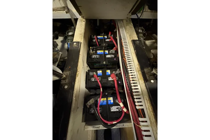 Slide: The Image of Battery compartment of a 2002 Carver 506 Motor Yacht with connected cables. - 77