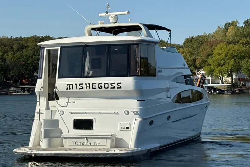 Slide: The Image of 2002 Carver 506 Motor Yacht on a serene lake, surrounded by lush trees. - 8