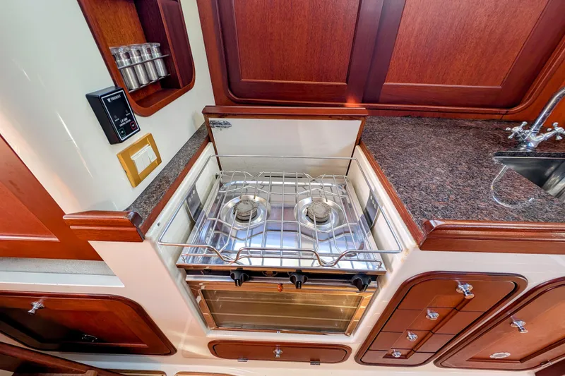 Slide: The Image of Galley kitchen in 2000 Santa Cruz Coastal Flyer 41 with stove and wooden cabinetry. - 42