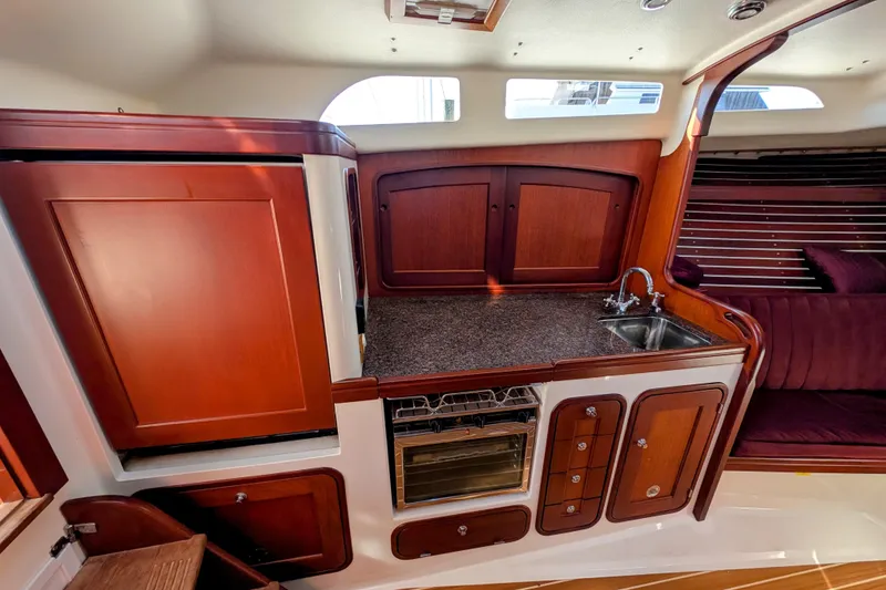 Slide: The Image of Interior of 2000 Santa Cruz Coastal Flyer 41 yacht with wooden cabinetry and compact kitchen. - 46