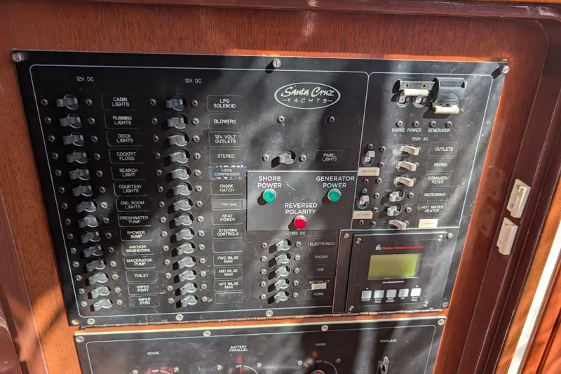 Slide: The Image of Control panel of a 2000 Santa Cruz Coastal Flyer 41 yacht, featuring various switches and indicators. - 53