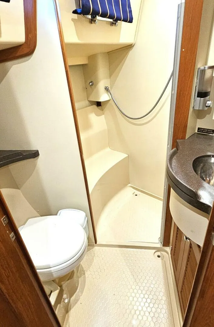 Slide: The Image of 2009 Island Packet 465 yacht bathroom with shower, toilet, and sink. - 11