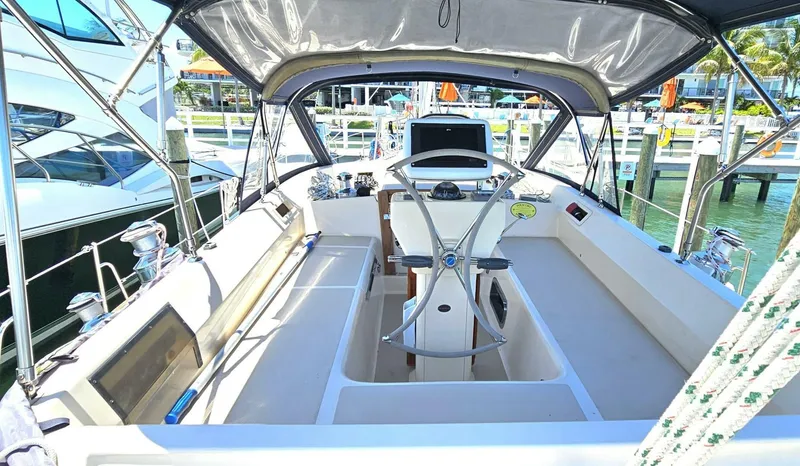 Slide: The Image of 2009 Island Packet 465 yacht cockpit with steering wheel and seating, docked at marina. - 12