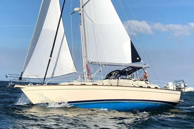 Slide: The Image of 2009 Island Packet 465 sailboat cruising on open water with full sails. - 14