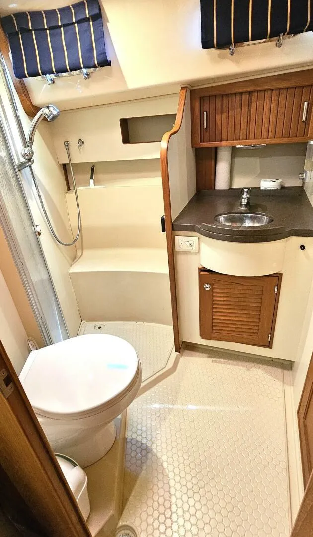 Slide: The Image of 2009 Island Packet 465 yacht bathroom with shower, sink, and wooden cabinetry. - 8