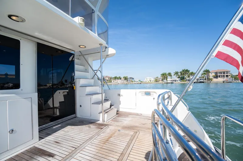 Slide: The Image of 2007 Ocean Alexander 52 Sedan yacht deck with American flag, overlooking waterfront homes. - 12