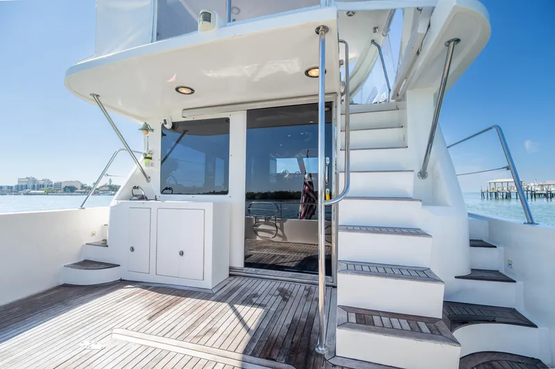 Slide: The Image of 2007 Ocean Alexander 52 Sedan yacht with wooden deck and staircase, docked by the water. - 13