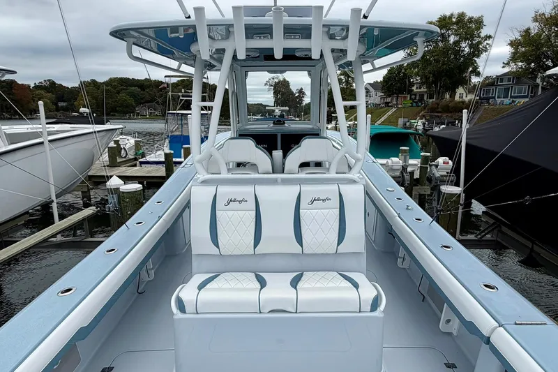 Slide: The Image of 2025 Yellowfin 36 Offshore boat interior at marina, showcasing seating and helm. - 11