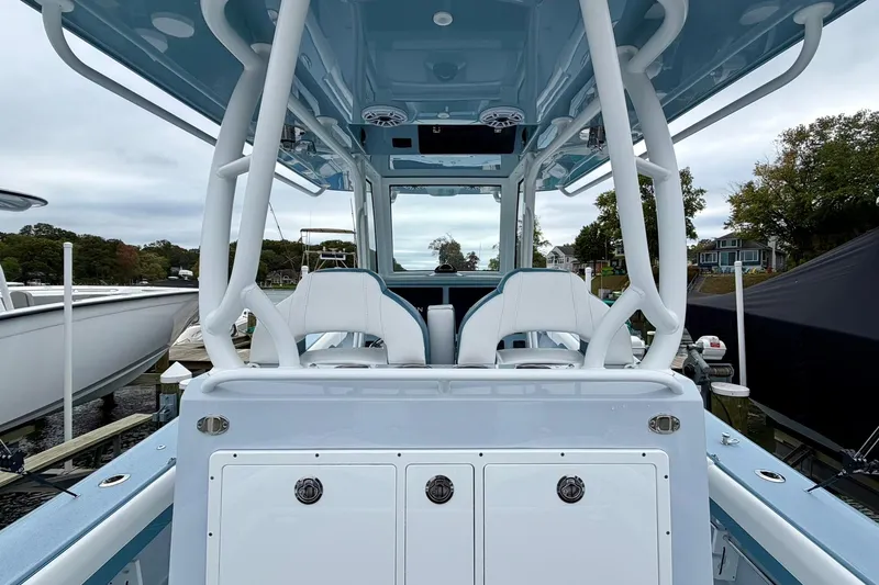 Slide: The Image of 2025 Yellowfin 36 Offshore boat interior with white seating and blue accents at a dock. - 13