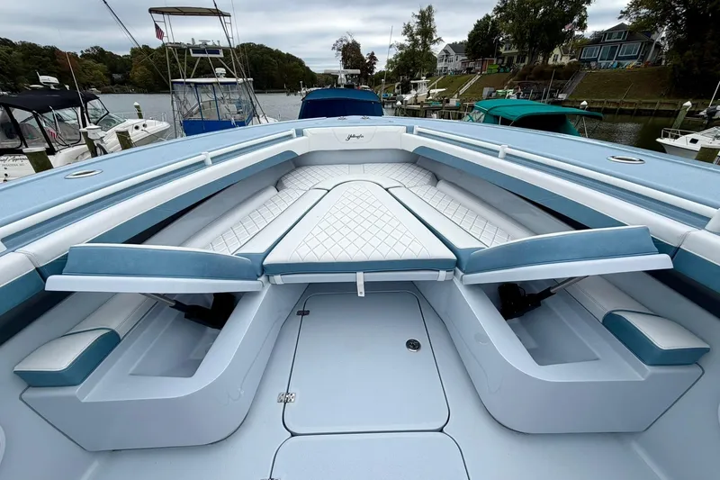 Slide: The Image of 2025 Yellowfin 36 Offshore boat interior with blue and white seating, docked in a marina. - 22