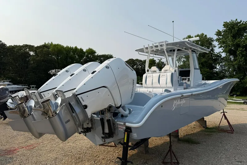 Slide: The Image of 2025 Yellowfin 36 Offshore boat with triple Mercury engines, parked on a gravel lot. - 30