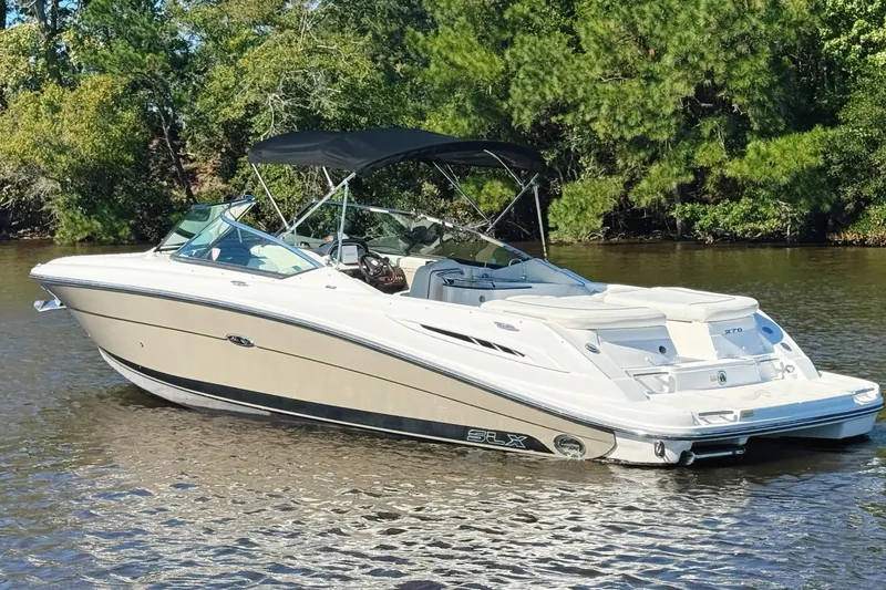 Slide: The Image of 2006 Sea Ray 270 SLX boat on calm water with lush green background. - 3