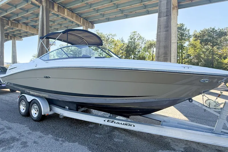 Slide: The Image of 2006 Sea Ray 270 SLX boat docked by a scenic waterfront under a clear blue sky. - 5