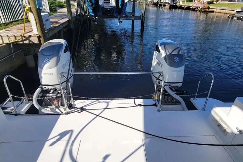 Slide: The Image of 2001 Zeta 32 Power Cat with dual Suzuki 350 engines docked by the water. - 11