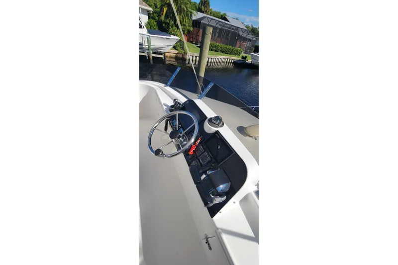 Slide: The Image of Helm of 2001 Zeta 32 Power Cat boat with steering wheel and controls. - 18