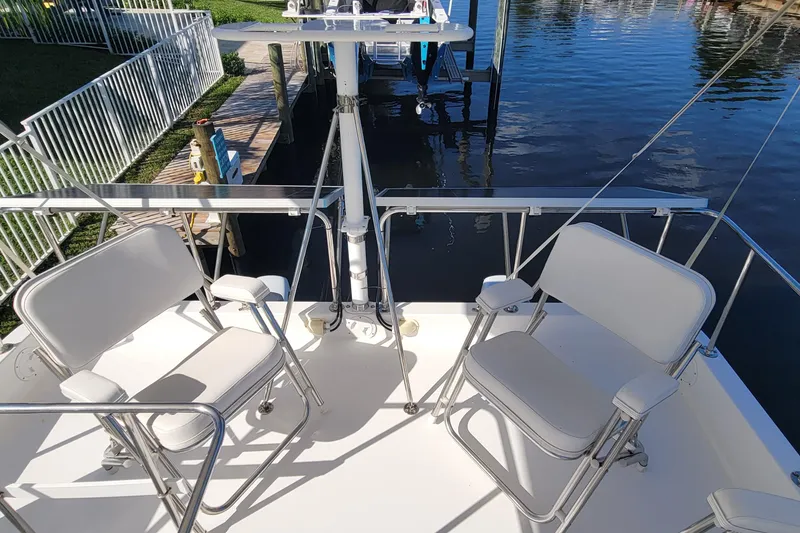 Slide: The Image of 2001 Zeta 32 Power Cat boat deck with white seating and railing by the water. - 23