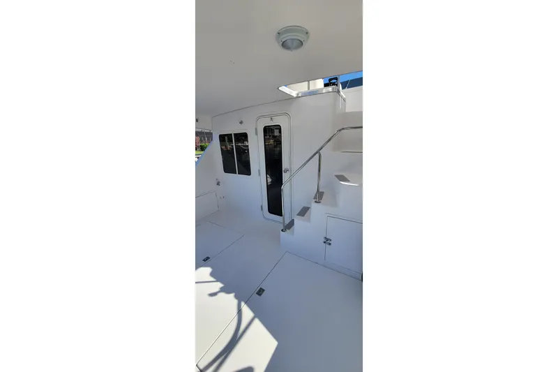 Slide: The Image of 2001 Zeta 32 Power Cat interior with stairs and door, featuring sleek white design. - 24