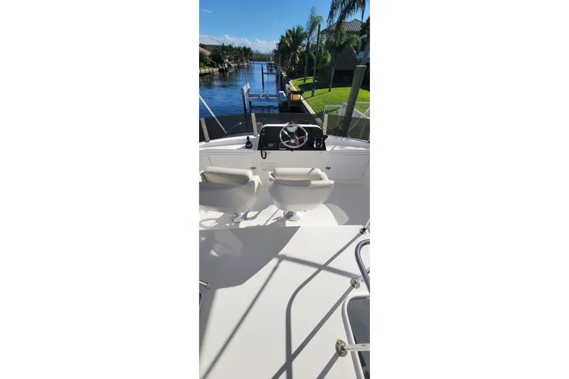 Slide: The Image of 2001 Zeta 32 Power Cat boat interior with steering wheel, seats, and waterway view. - 32