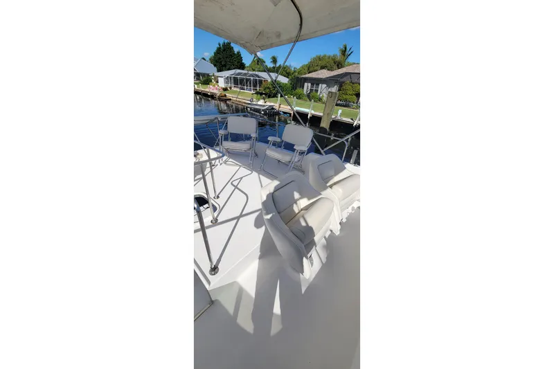 Slide: The Image of 2001 Zeta 32 Power Cat boat interior with white seating and waterfront view. - 33