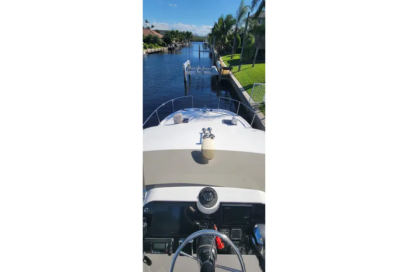 Slide: The Image of 2001 Zeta 32 Power Cat on a serene canal with palm trees. - 38