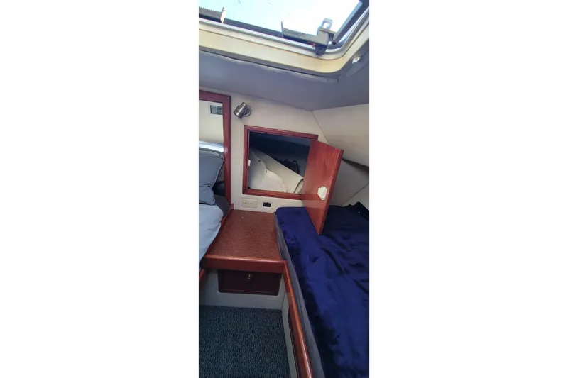 Slide: The Image of Interior cabin of 2001 Zeta 32 Power Cat with wooden accents and blue bedding. - 58