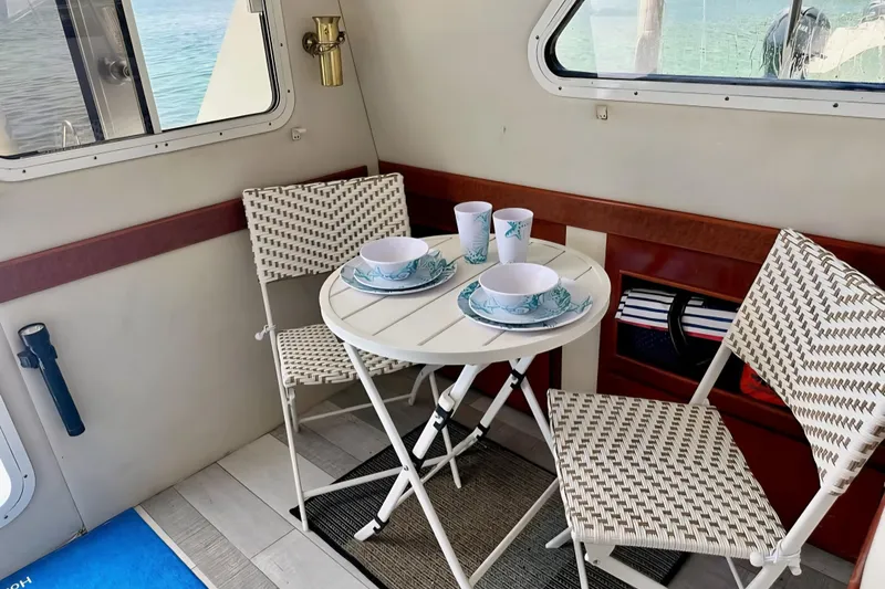 Slide: The Image of Cozy dining setup on 2001 Zeta 32 Power Cat with wicker chairs and nautical tableware. - 8