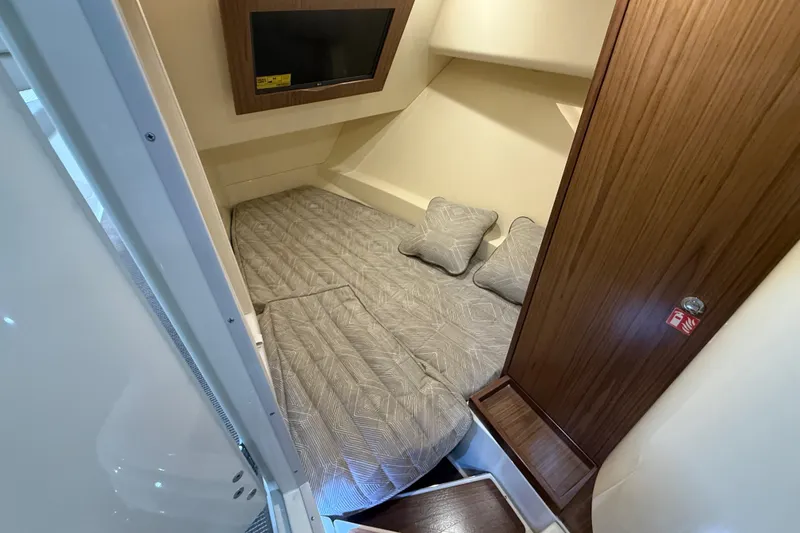 Slide: The Image of 2026 Chris-Craft Launch 35 GT cabin interior with bed, pillows, and TV. - 23