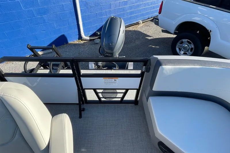 Slide: The Image of 2026 Starcraft GX 16 R boat interior with seating and motor, parked near a blue wall. - 10