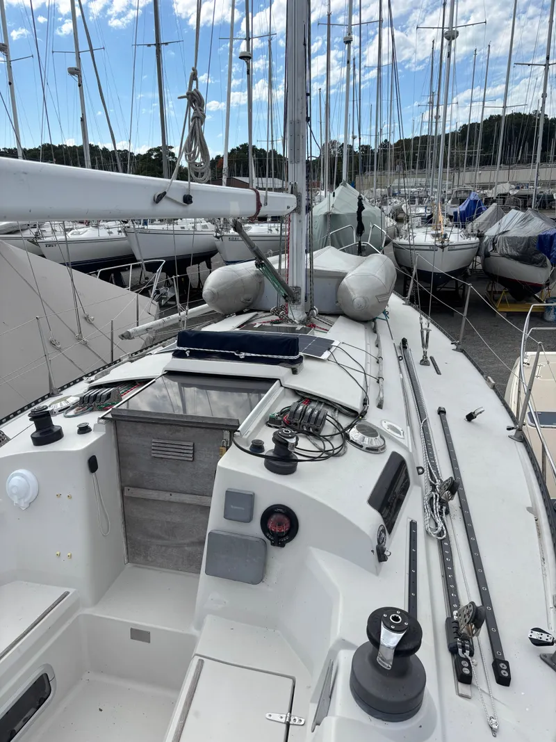 Slide: The Image of 1987 Goman Express 35 sailboat docked, surrounded by other boats under a partly cloudy sky. - 14