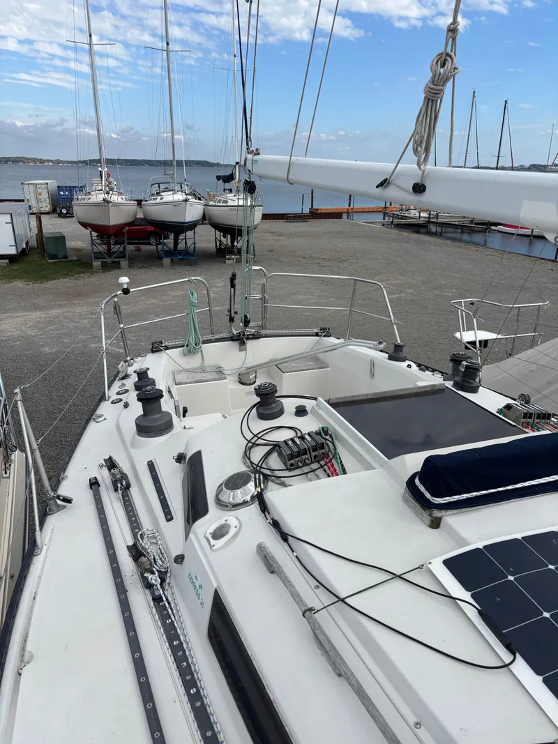 Slide: The Image of Sailboat deck view of 1987 Goman Express 35, docked near a marina with other boats. - 19