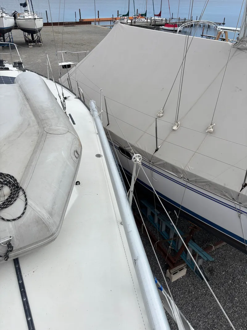 Slide: The Image of 1987 Goman Express 35 sailboat on dry dock, covered and adjacent to another vessel. - 29