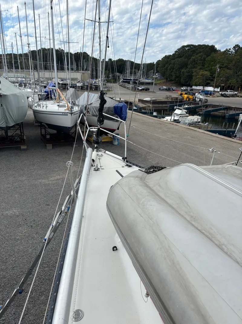 Slide: The Image of 1987 Goman Express 35 sailboat on dry dock, surrounded by other boats and marina. - 34