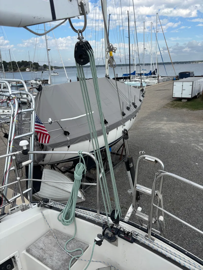 Slide: The Image of 1987 Goman Express 35 sailboat docked with American flag, marina in background. - 40