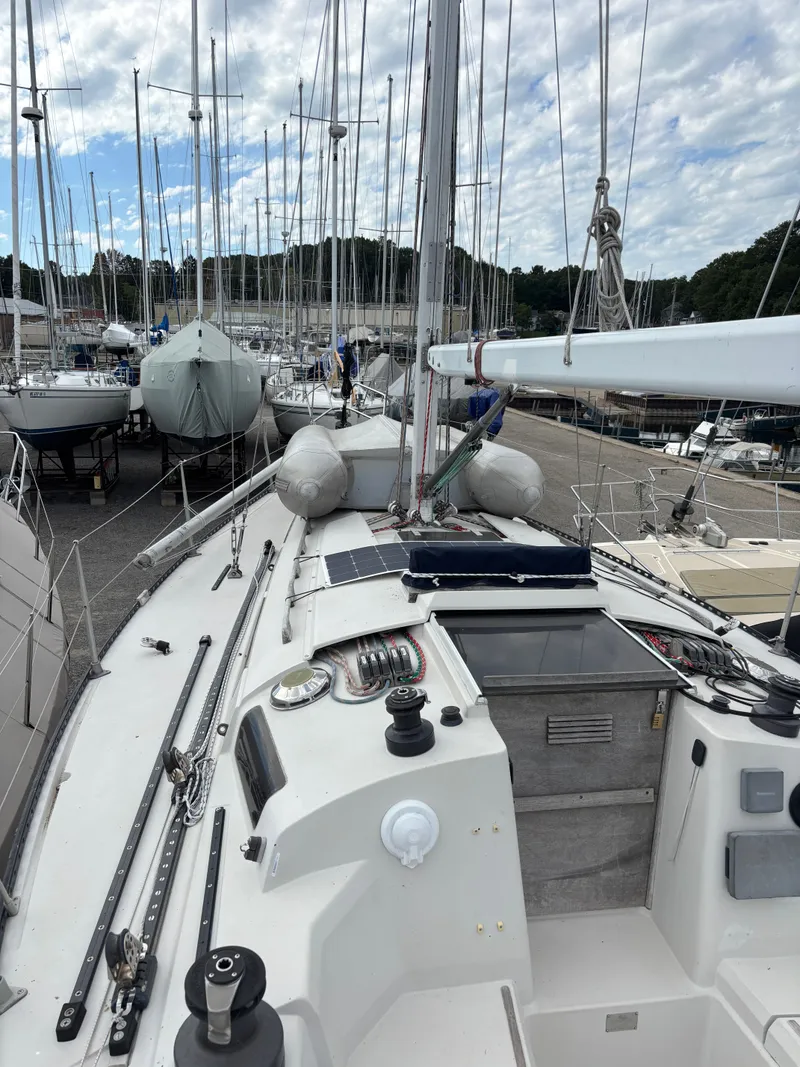 Slide: The Image of 1987 Goman Express 35 sailboat docked, showcasing deck and rigging under cloudy sky. - 42