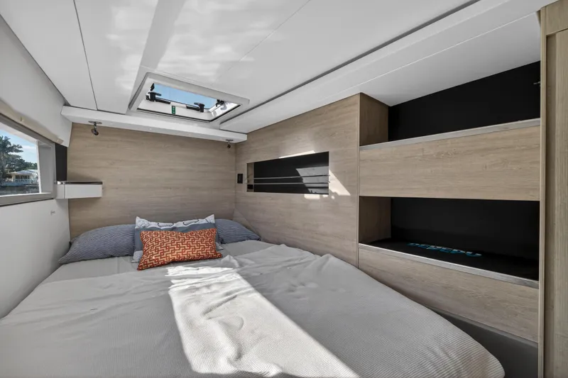 Slide: The Image of Modern bedroom interior in a 2019 Leopard 45 yacht, featuring skylight and wooden accents. - 106