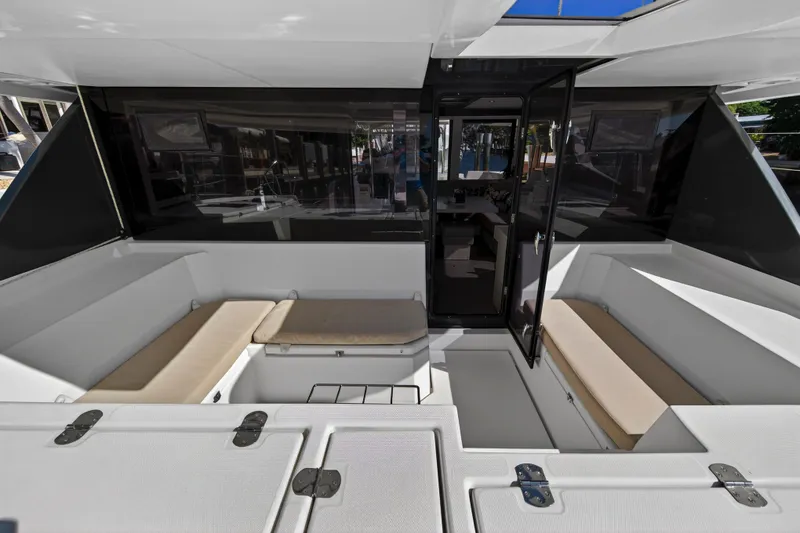 Slide: The Image of 2019 Leopard 45 catamaran cockpit with cushioned seating and open door to interior. - 14
