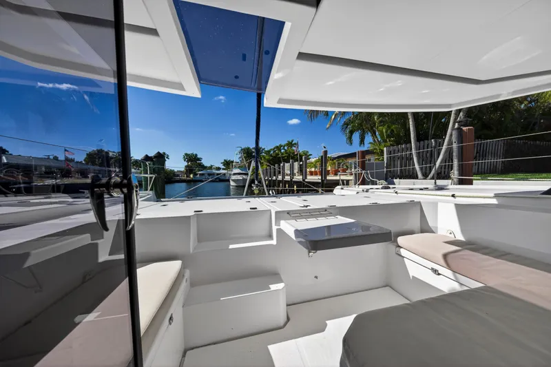 Slide: The Image of 2019 Leopard 45 catamaran interior with seating, docked by a sunny waterfront. - 15