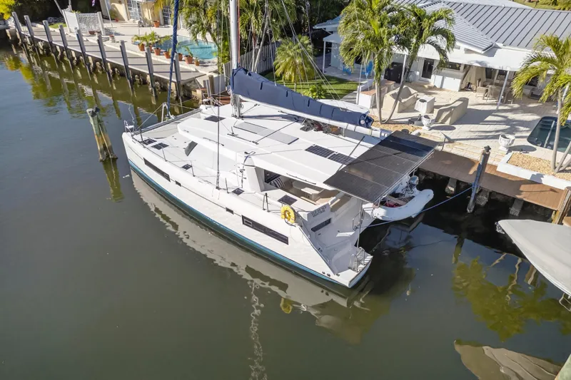Slide: The Image of 2019 Leopard 45 catamaran docked by a waterfront home with palm trees. - 27