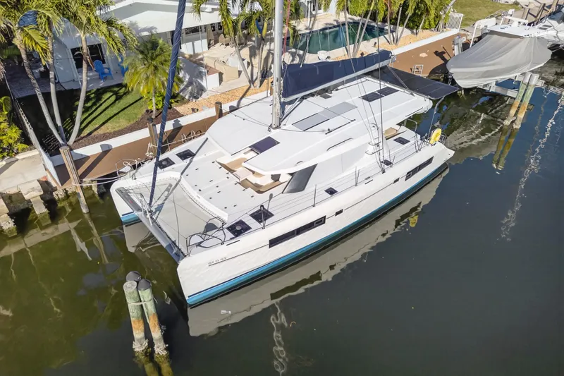 Slide: The Image of 2019 Leopard 45 catamaran docked by a waterfront home with lush greenery. - 31
