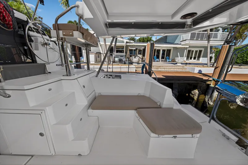 Slide: The Image of 2019 Leopard 45 yacht cockpit with seating, steering wheel, and dock view. - 40