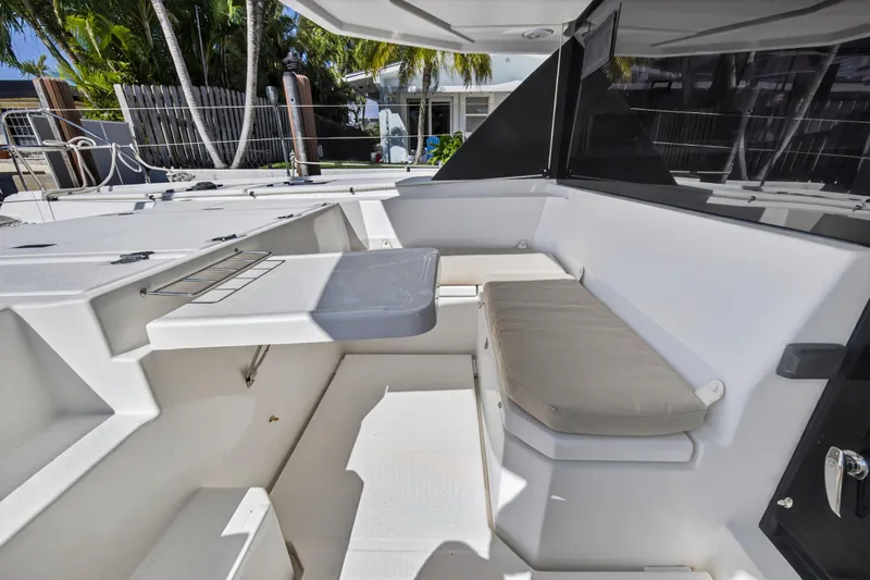 Slide: The Image of 2019 Leopard 45 yacht cockpit with seating, table, and tropical background. - 63