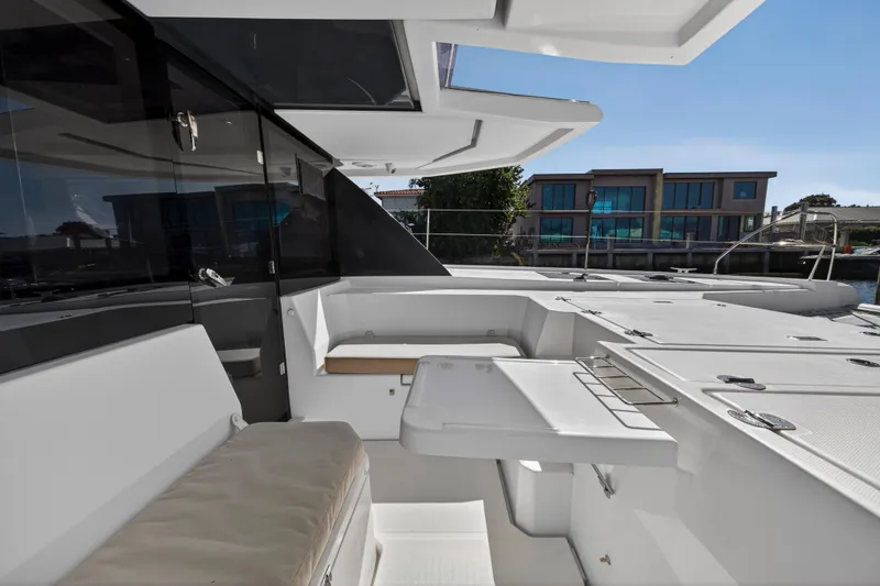 Slide: The Image of 2019 Leopard 45 yacht deck with seating and table, modern waterfront view. - 64