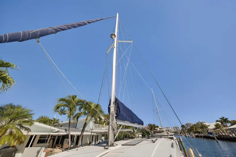 Slide: The Image of Sailboat docked by palm trees, Leopard 45 model, 2019, under clear blue sky. - 71