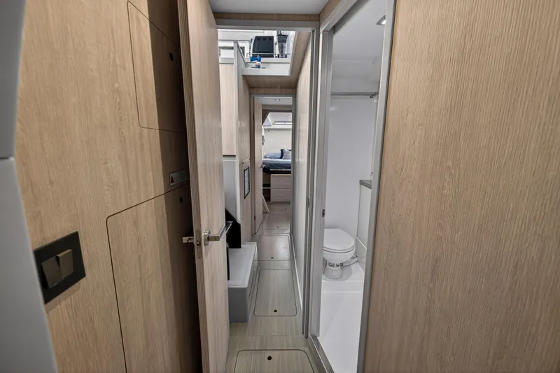 Slide: The Image of Interior of 2019 Leopard 45 yacht, featuring a modern bathroom and hallway with wooden finishes. - 97