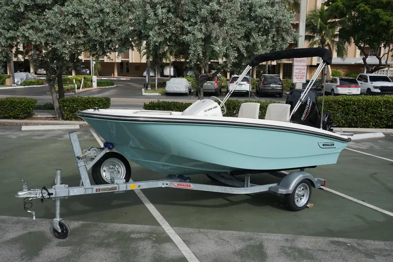 The Image of 2026 Boston Whaler 130 Super Sport boat on trailer in parking lot. - 0