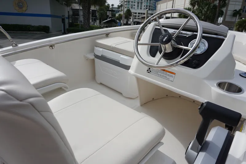 Slide: The Image of 2026 Boston Whaler 130 Super Sport boat interior with steering wheel and seating. - 10